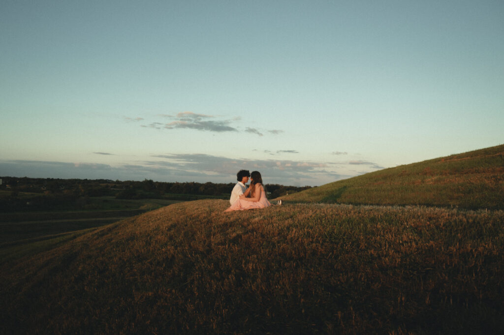 a couple sitting face to face on a hill at celery fields for a cinematic shot
