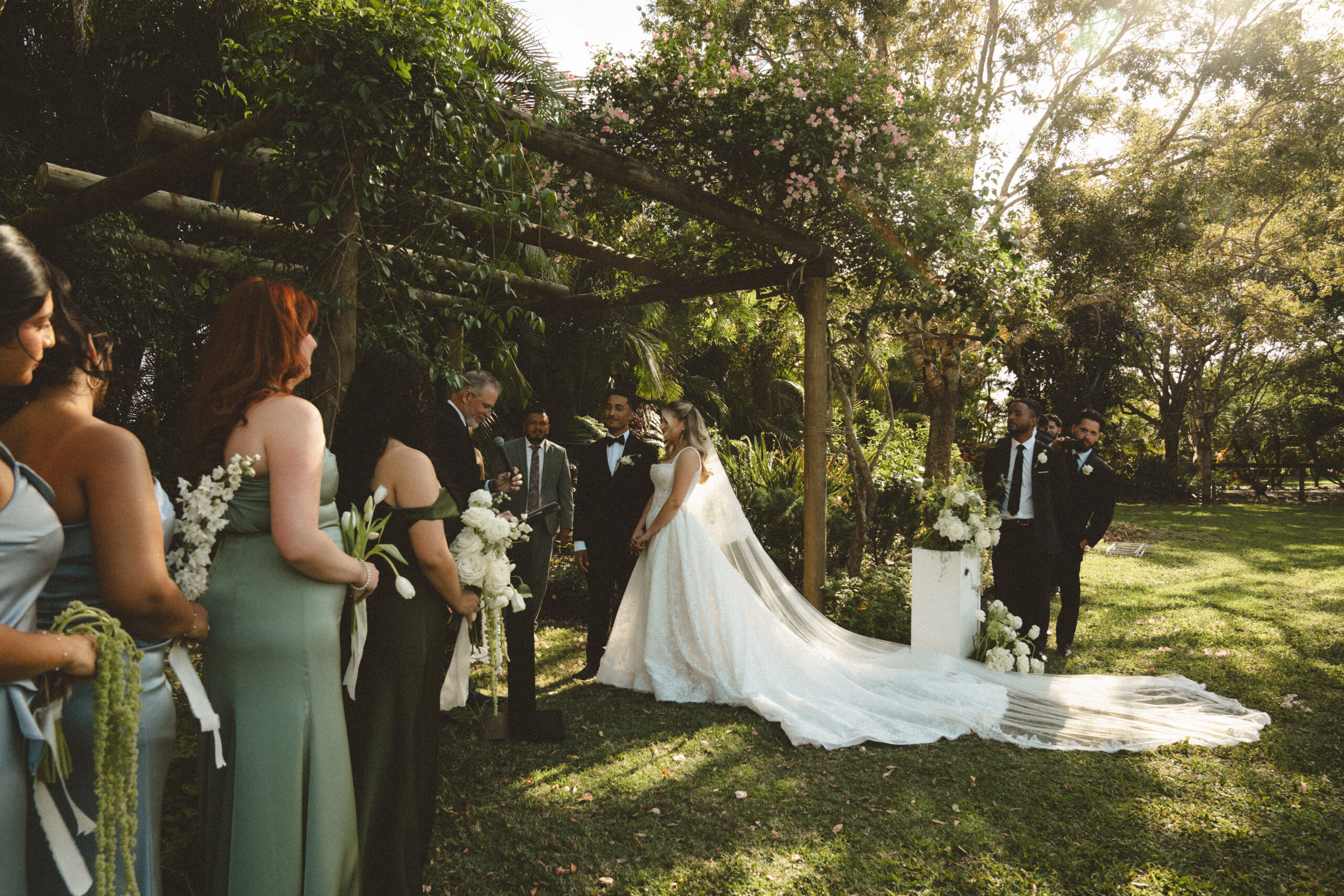 bride and groom standard at their wedding altar under greenery waiting to say their vows