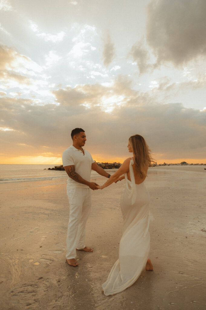a couple walking in a circle around each other at sunset on Upham during their St. Petersburg engagement photos