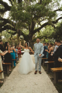 bride and groom celebrate as they walk down the aisle after getting married