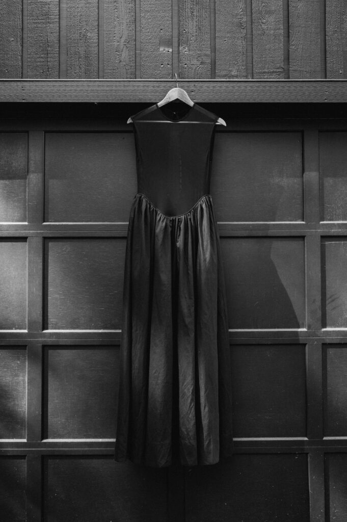 a black wedding dress hanging up for a photo