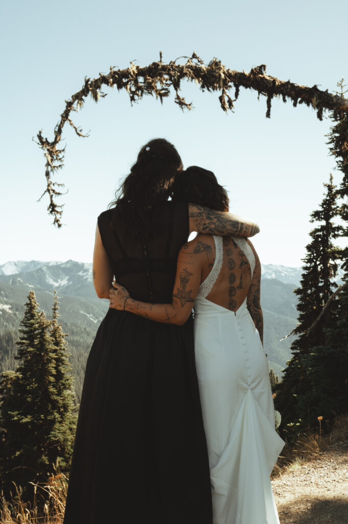 brides embracing as they look out at at the views on hurricane ridge