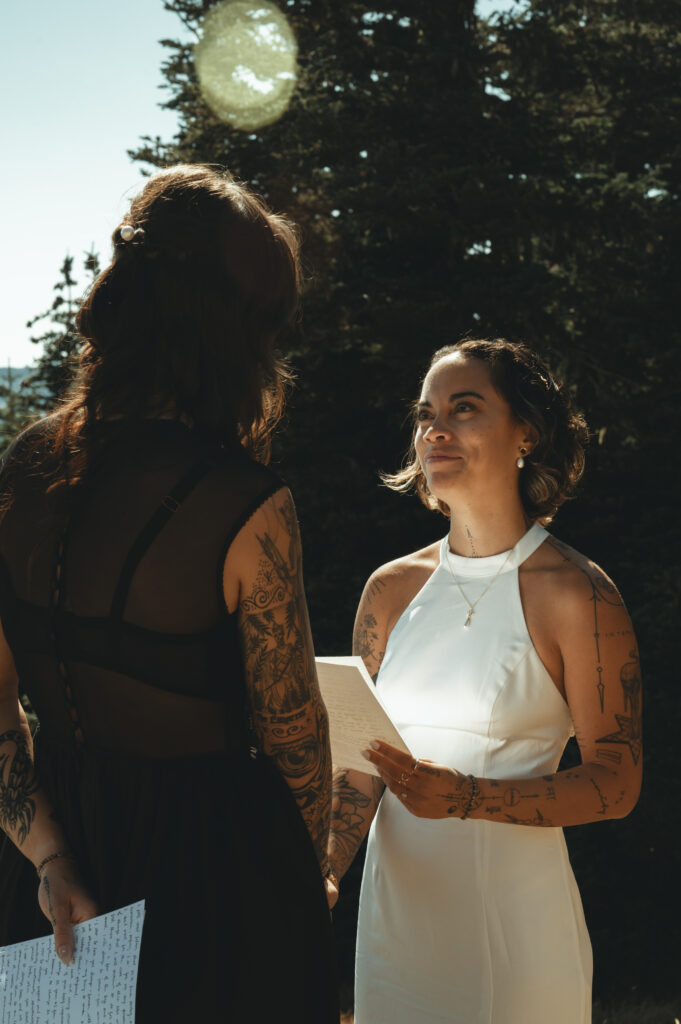 brides reading vows to each other on top of a mountain
