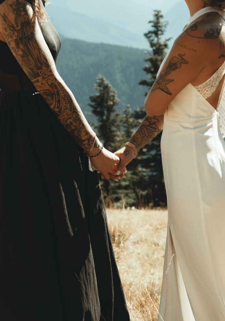 brides hold hands during their elopement ceremony