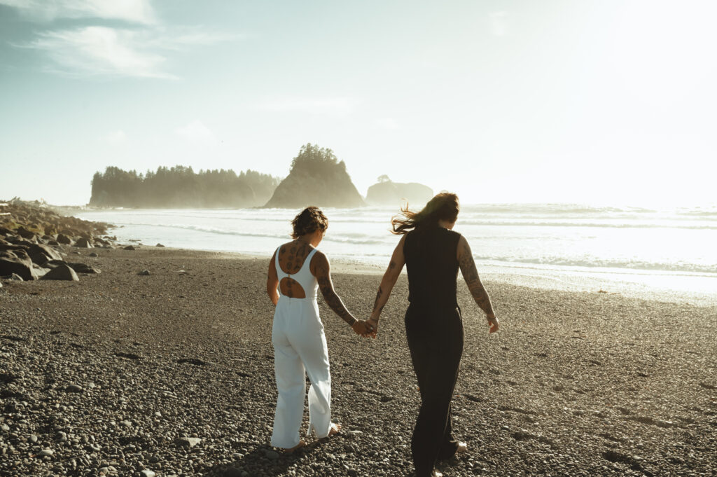 brides walking hand-in-hand on rialto beach near sunset