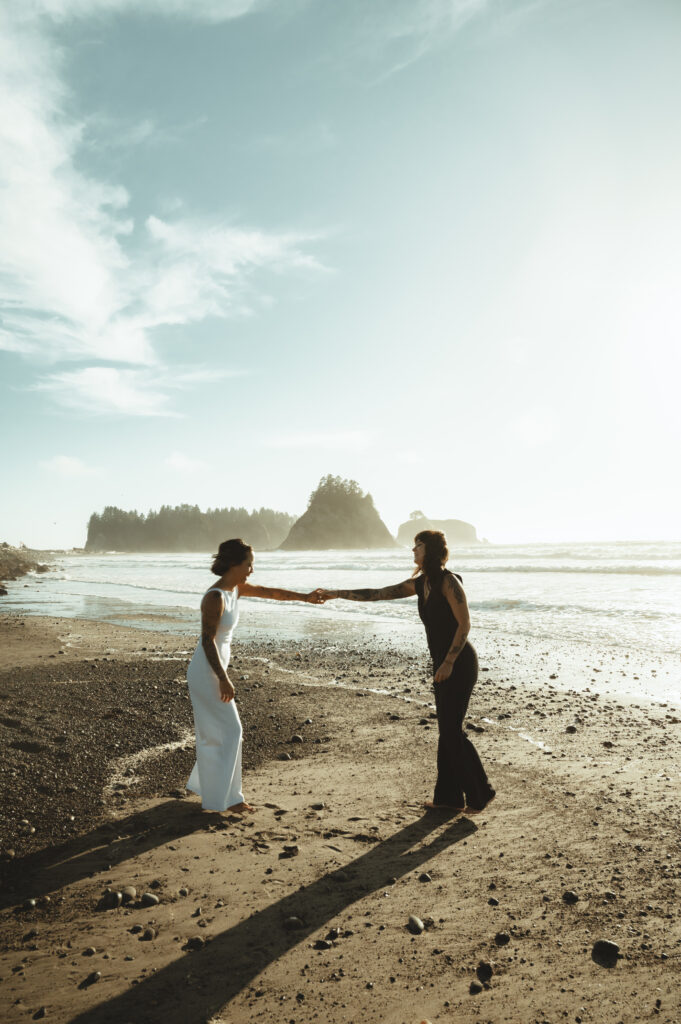 two women spinning hand in hand at rialto beach