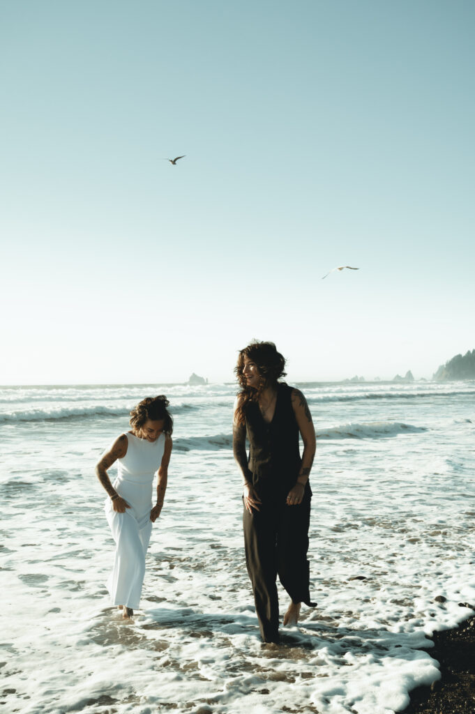 two brides running in the ocean on Washington's coast
