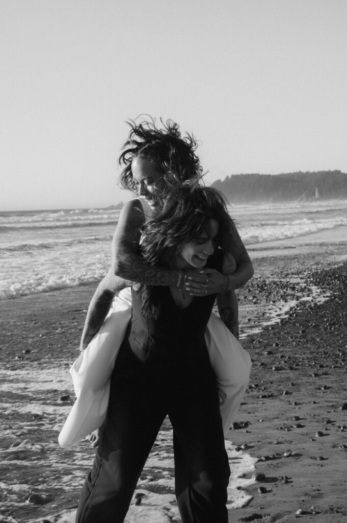 candid shot of a bride on her wife's back running around rialto beach