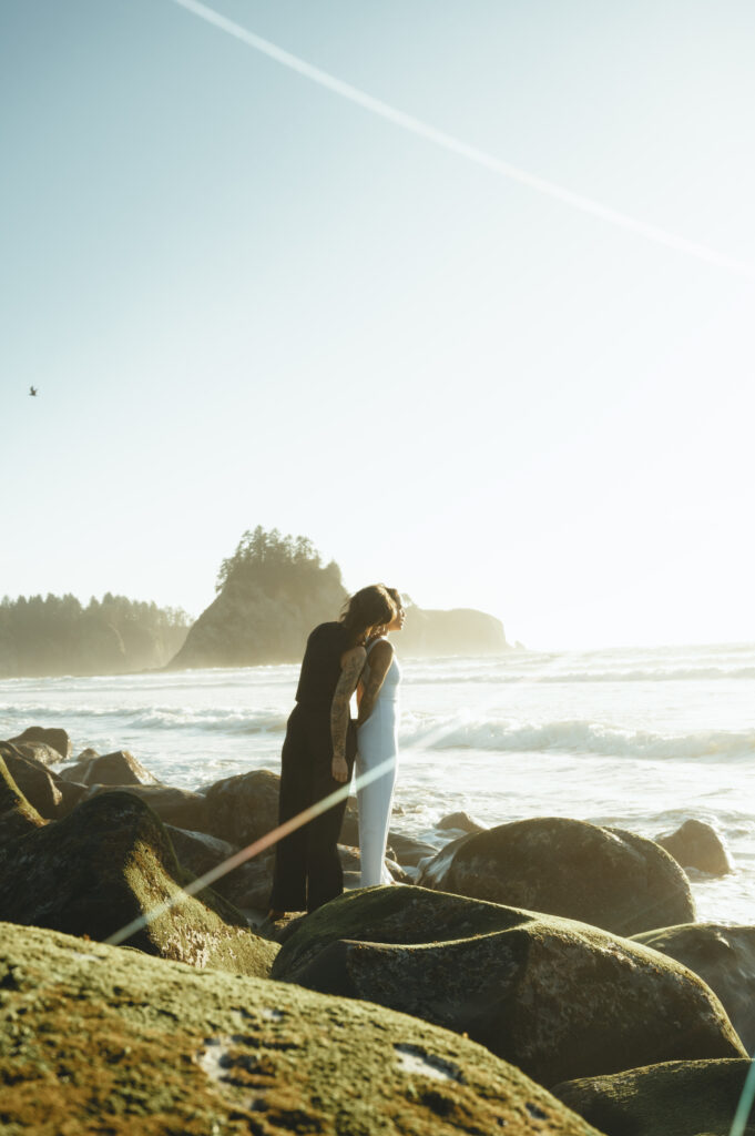 brides embracing on the rocks at rialto beach