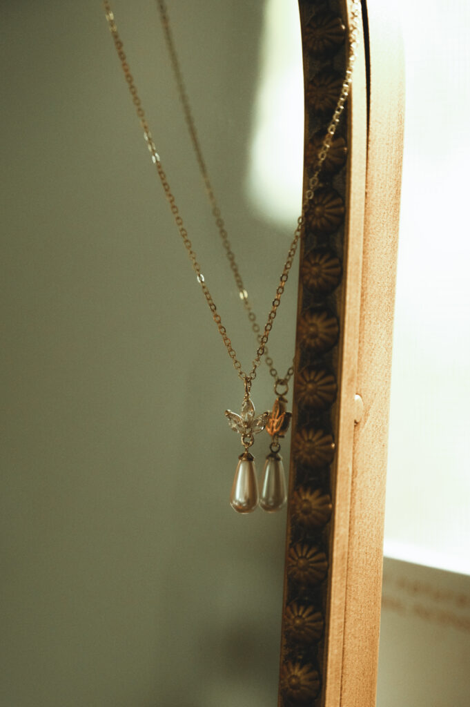 a necklace hanging on a mirror for a detail shot
