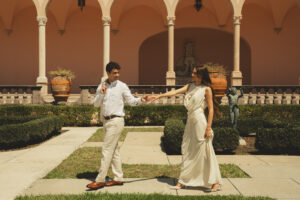 A groom leading his bride through the gardens of The Ringling museum