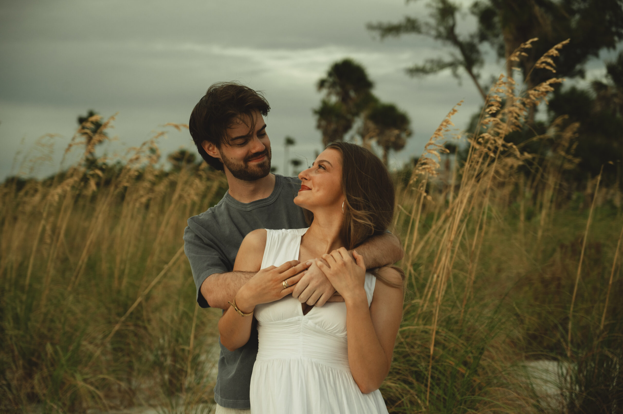 couple embraces on the beach in Florida during their engagement photos