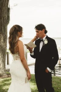 documentary photo of bride wiping grooms tears has he reads his vows to her