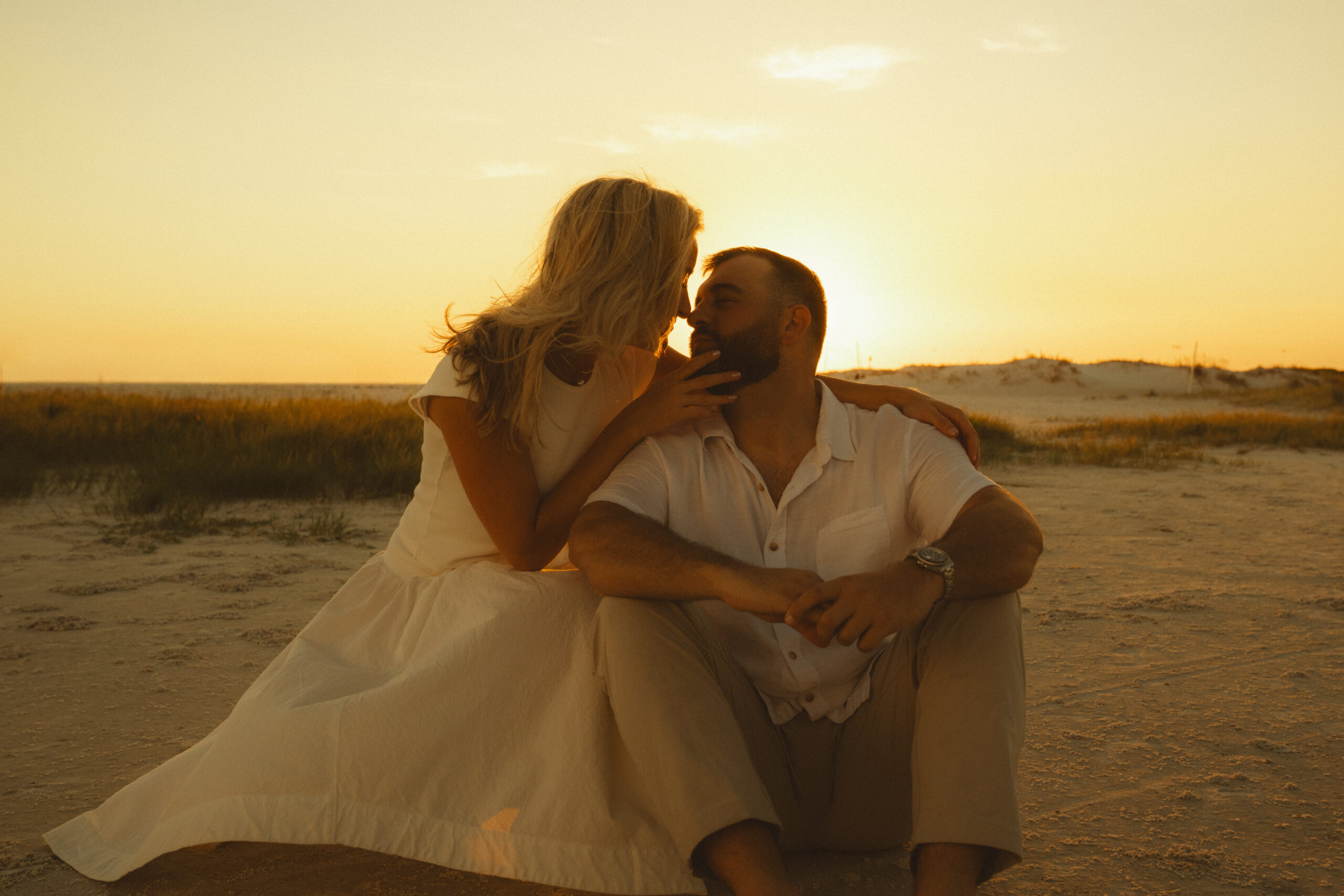 couple sitting on fort desoto beach touching foreheads for their elopement photos
