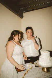 candid shot of brides enjoying their cake after they cut it
