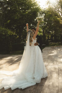 candid photo of bride throwing her hands up in celebration